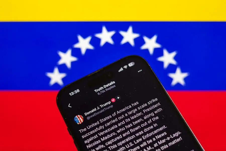epa12623106 Illustration of a statement by US President Donald Trump posted on his Social Truth profile, pictured with the Venezuelan flag in the background, in Prague, Czech Republic, 03 January 2026. US President Trump announced that a 'large-scale strike' on Caracas resulted in the capture of Venezuelan leader Nicolas Maduro and his wife, who were reportedly flown out of the country. The Venezuelan government denounced the US operation as a 'serious military aggression'. EPA/MARTIN DIVISEK