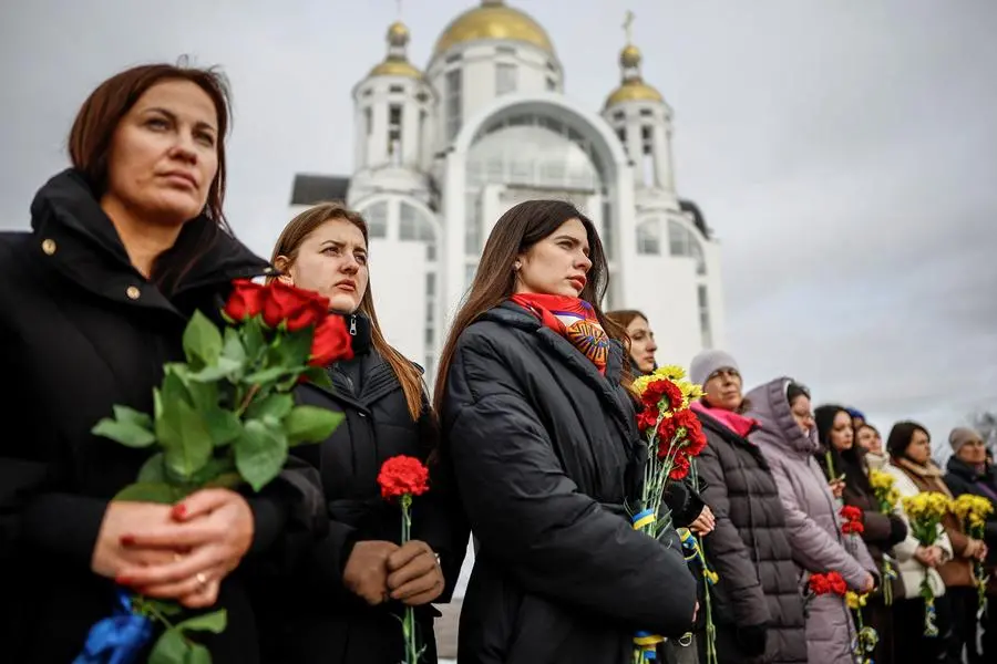 Donne ucraine depongono fiori presso il memoriale per le vittime dell\\'aggressione russa a Bucha, nella regione di Kyiv, nel giorno del quarto anniversario dell\\'invasione su vasta scala, il 24 febbraio. , REUTERS