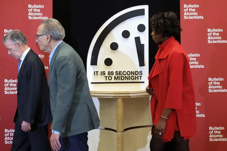 Colombia's former President Juan Manuel Santos, chair of The Elders, Robert Socolow, professor emeritus in the Department of Mechanical and Aerospace Engineering at Princeton University, and Suzet McKinney, principal and director of Life Sciences for Sterling Bay, walk past the Doomsday Clock after revealing the location of the clock’s minute hand, which according to the Bulletin of the Atomic Scientists, indicates what world developments mean for the perceived likelihood of nuclear catastrophe, during a press conference at the U.S. Institute of Peace in Washington, U.S., January 28, 2025. REUTERS/Kevin Lamarque