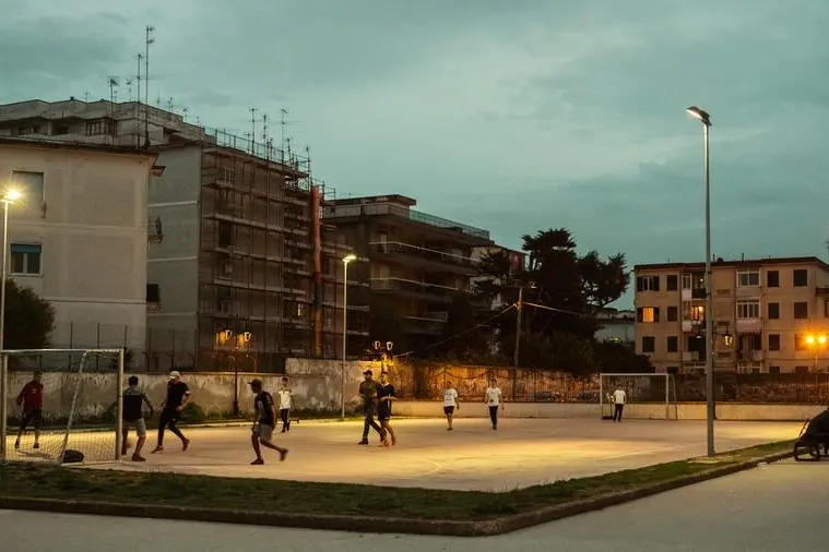 Ragazzi giocano a calcio in un campetto nella periferia di Napoli. , iStock