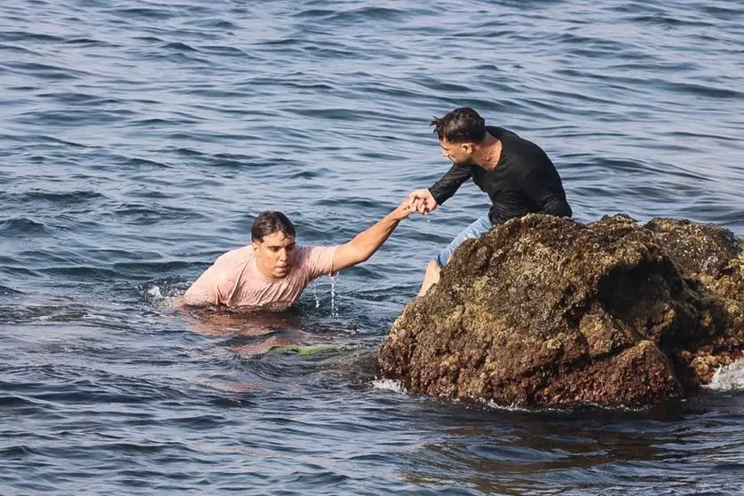 Un migrante grazie all'aiuto di un abitante di Ceuta riesce a raggiungere la costa dopo la traversata a nuoto