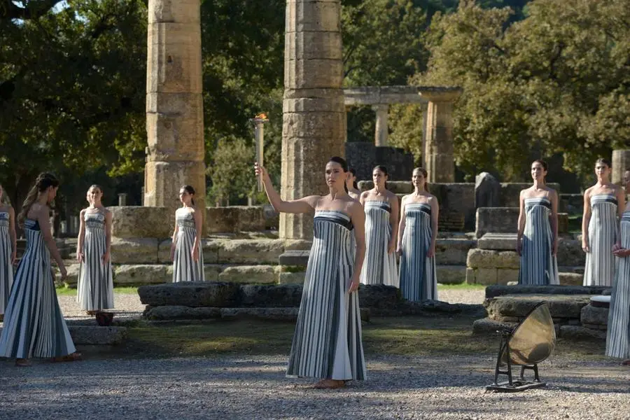 epa12545817 Greek actress Mary Mina (C), playing the role of High Priestess, holds the flame during the rehearsal of the Olympic flame lighting ceremony for the Milano Cortina 2026 Winter Olympics at the Ancient Olympia site in southern Greece, 24 November 2025. The Milano Cortina 2026 Winter Olympics will be held from 06 February to 22 February 2026. EPA/DIMITRIS PAPAIOANNOU