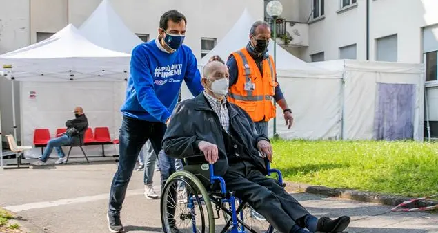 Accanto, in ogni tappa del percorso, agli anziani che si vaccinano