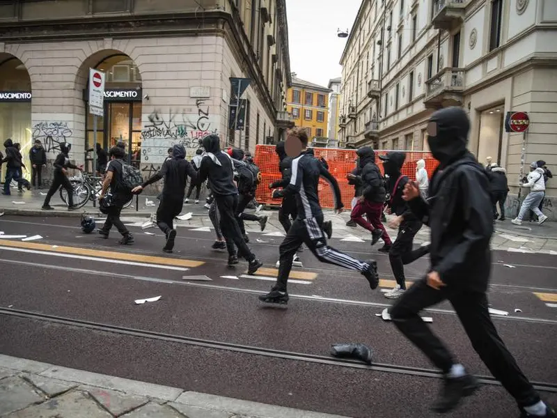 Dopo gli scontri a Milano, due facce da bambini e gli occhi sul cellulare
