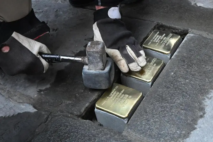 L\\u2019artista tedesco Gunter Demnig, ideatore delle \\u201CStolpersteine\\u201D, piccole targhe da selciato nate con lo scopo di lasciare nelle citt\\u00E0 una memoria dei deportati nei campi di sterminio nazisti, corso Magenta 5, dove sono state posate in memoria di Ida, Arturo e Luciano Valabrega. Genova, 10 gennaio 2024. ANSA/LUCA ZENNARO , ANSA