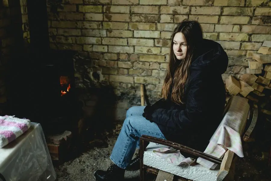 Schenia, una ragazzina di 15 anni di Irpin, cerca di riscaldarsi nella casa della sua famiglia ridotta in macerie. , Florian Bachmeier per WeWorld