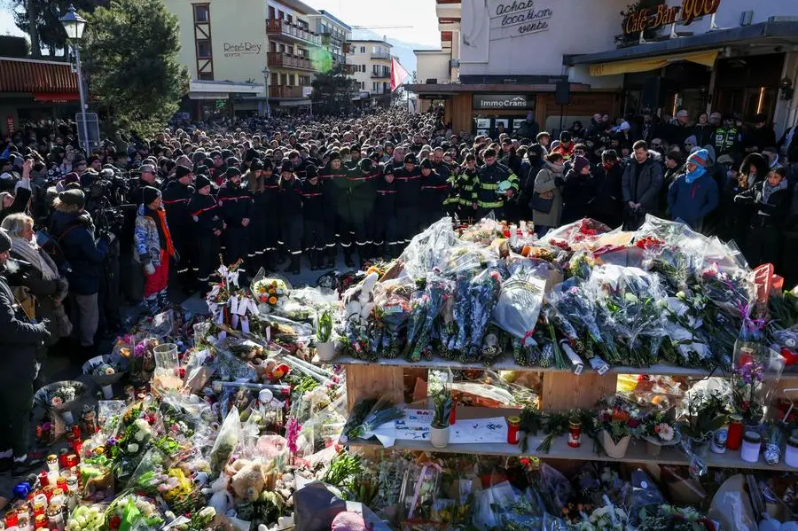 Firefighters and other people mourn at a makeshift memorial outside the \\\"Le Constellation\\\" bar, after a deadly fire and explosion during a New Year's Eve party in the upscale ski resort of Crans-Montana in southwestern Switzerland, January 4, 2026. REUTERS/Umit Bektas