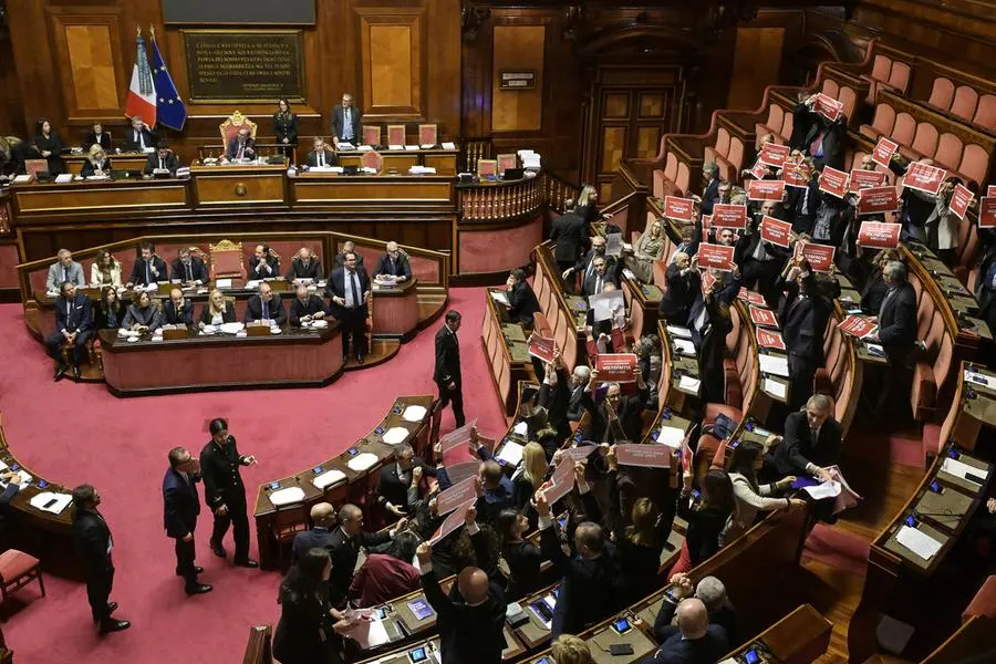 Protesta delle opposizioni in Aula al Senato poco prima del voto sulla fiducia sulla manovra, Roma, 23 dicembre 2025. I senatori di Pd, M5S e Avs hanno esposto dei cartelli rossi con la scritta bianca 'Voltafaccia Meloni'. ANSA/RICCARDO ANTIMIANI