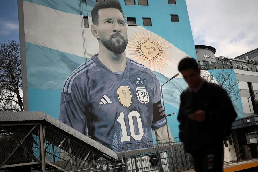 Un pendolare davanti a un murale di Leo Messi alla stazione Villa del Parque train a Buenos Aires, Argentina, 31 agosto, 2026. , REUTERS