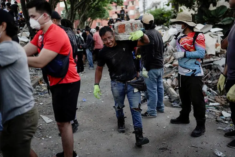 Gente al lavoro a Cali per rimuovere le macerie.