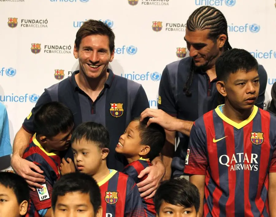 Lionel Messi (a sinistra) e Jose Manuel Pinto (a destra) e alcuni bambini nel 2013, quando l'Unicef era lo sponsor del Barcellona