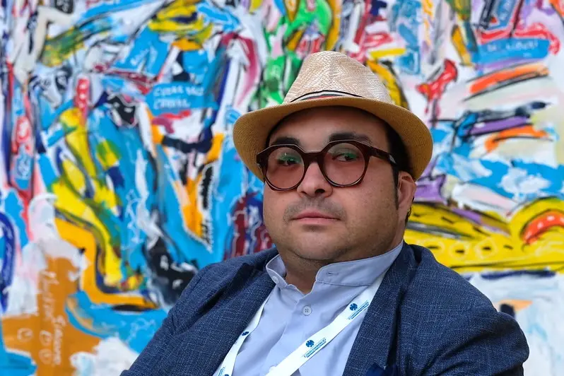 Marck Art posa davanti a un suo dipinto. La prima mostra risale al 2009, a Palermo.