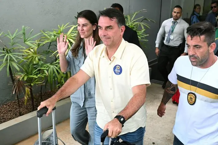 Brazil\\'s right-wing Senator and Liberal Party (PL) presidential candidate Flavio Bolsonaro arrives with his wife Fernanda at Presidente Juscelino Kubitschek International Airport during Brazil\\'s presidential runoff election in Brasilia, Brazil, on October 25, 2026. Flavio Bolsonaro faces President Luiz Inacio Lula da Silva in a runoff that will determine whether Brazil remains one of the few leftist nations in the region or joins a regional swing to the right championed by his ally, US President Donald Trump. (Photo by Evaristo SA / AFP) , AFP