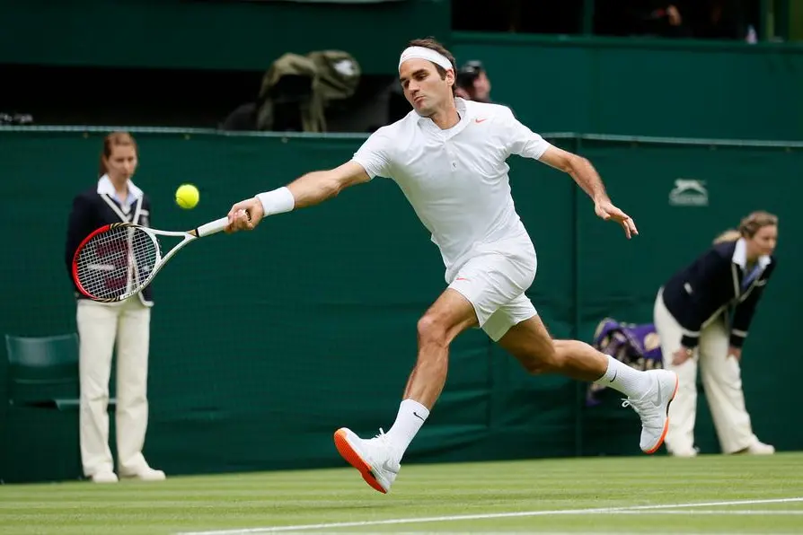 Roger Federer of Switzerland hits a return to Victor Hanescu of Romania in their men's singles tennis match at the Wimbledon Tennis Championships, in London June 24, 2013. REUTERS/Stefan Wermuth (BRITAIN - Tags: SPORT TENNIS)