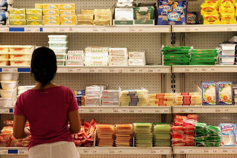 20070712 - ROMA - FIN - EURISPES, 5MLN DI FAMIGLIE POVERE O A RISCHIO. Una donna confronta il prezzo di alcuni prodotti alimentari in un supermercato del centro di Milano, in una immagine del 18 agosto 2005. Sono circa 5.100.000 i nuclei familiari gia' indigenti o a rischio poverta'. Lo rileva uno studio realizzato da Eurispes in collaborazione con Federcasalinghe. Il 23% delle famiglie italiane e piu' di 15 milioni di individui -di questi quasi tre milioni sono minori di 18 anni- sono poveri o rischiano di diventarlo. Basta un divorzio, la perdita del lavoro o il sopraggiungere di una malattia a compremettere l'equilibrio economico-finanziario di una consistente quota di nuclei familiari. Ad incidere negativamente sulle condizioni di vita della popolazione sono, poi, l'impennata del credito al consumo, la modesta ripresa dei consumi, l'aumento dei prezzi ''regolamentati'', le tariffe di trasporto e altri servizi di pubblica utilita'. ANSA/ARCHIVIO/DANIEL DAL ZENNARO/DRN