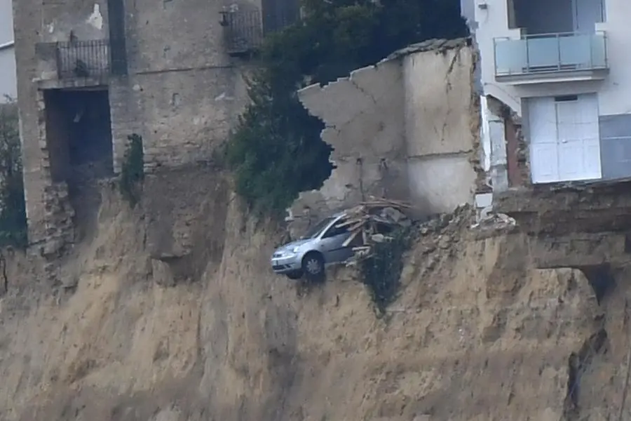 Un\\'automobile rimasta in bilico sul limite dell\\'area colpita dalla frana a Niscemi, Caltanissetta. La frana ha causato l\\'evacuazione di centinaia di famiglie e danni ingenti al patrimonio edilizio , ANSA