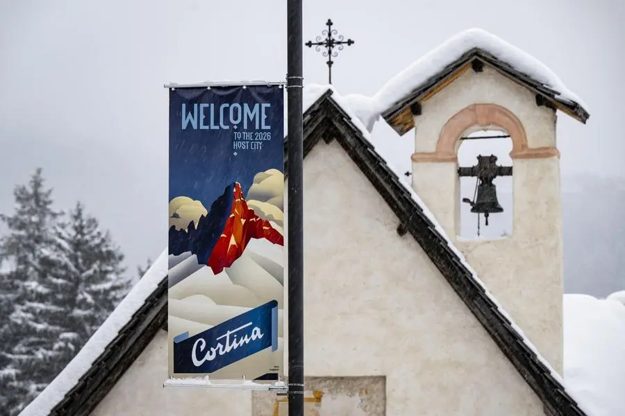 Uno striscione con la scritta “Benvenuti nella città ospitante del 2026” a Cortina in vista dei Giochi