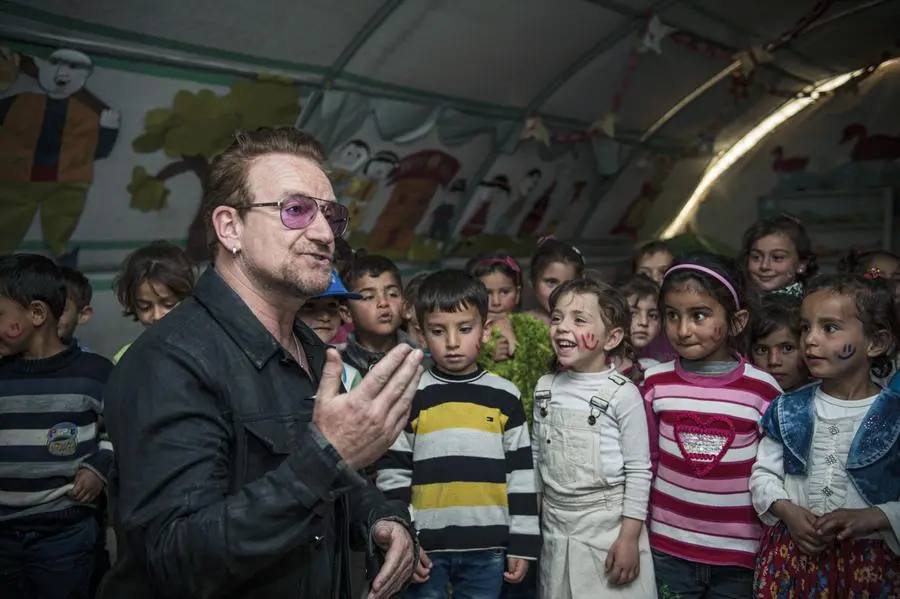 Il leader e cantante Bono in visita all’asilo di un campo profughi per siriani in Turchia.
