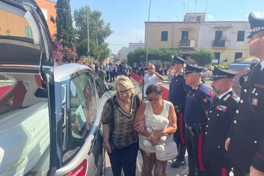 La madre Antonietta stringe il peluche d'infanzia della figlia all'arrivo del feretro di Lorena Isceri per il funerale a Squinzano (Lecce)