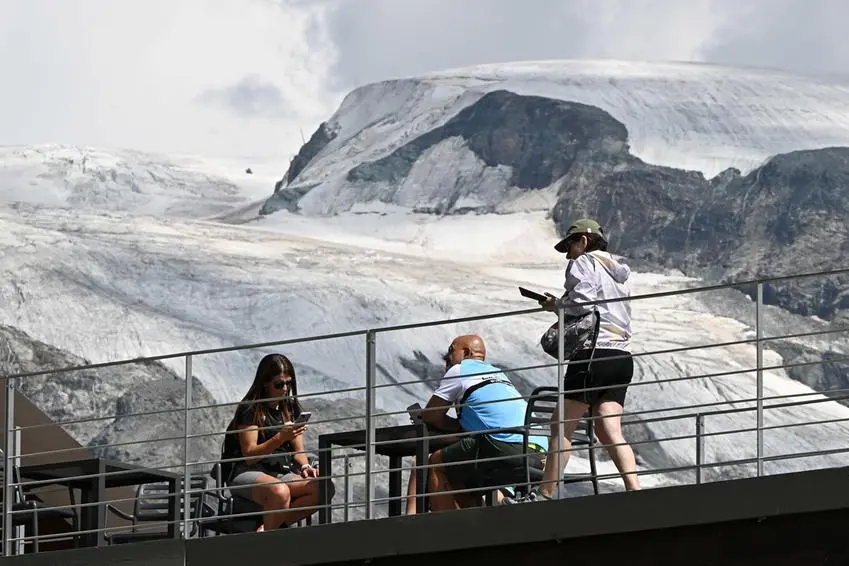 Ghiaccio e neve in ritirata su tutto l\\'arco alpino. Dietro ai turisti, la Gobba di Rollin (3.899 metri), di fronte al Cervino, un tempo ricoperta da spesso ghiaccio , ANSA