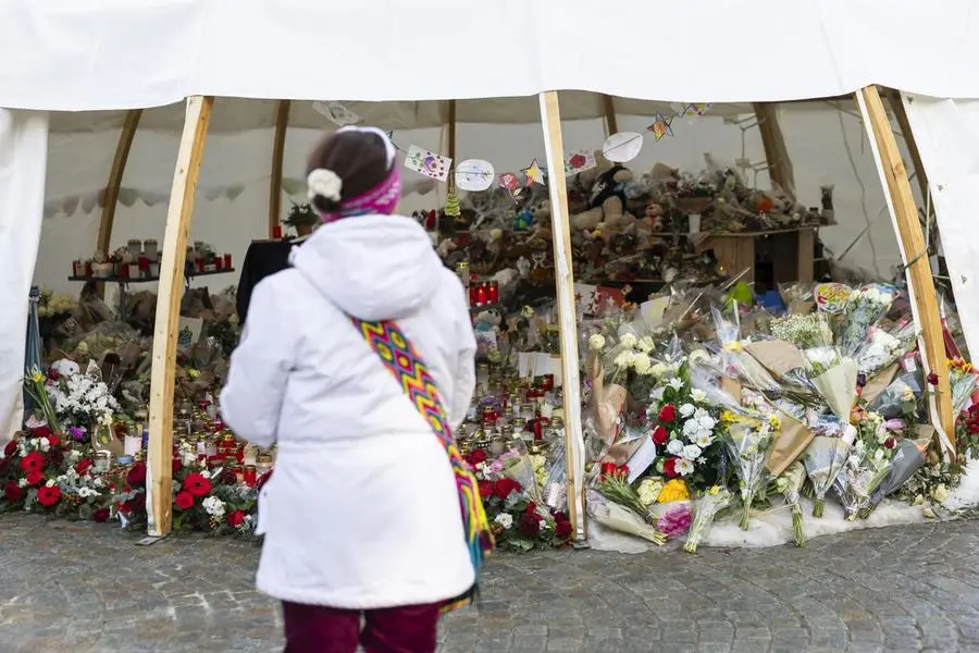 epa12648739 Flowers and candles are left in tribute to the victims after the fire at a bar in Crans-Montana, Switzerland, 14 January 2026. 40 people mostly teenagers lost their lives and 116 were severely injured in the fire at the bar 'Le Constellation' on New Year's celebration in the Swiss Alps resort of Crans-Montana. EPA/CYRIL GYPSY