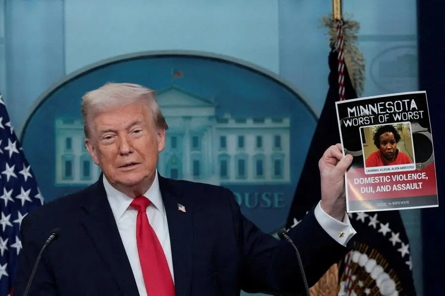 Donald Trump mostra un poster di un presunto criminale arrestato dall\\'ICE nelle strade del Minnesota durante una conferenza stampa alla Casa Bianca, in occasione del primo anniversario del suo secondo mandato , REUTERS