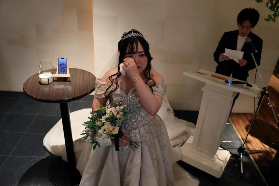 Yurina Noguchi, 32, wipes away tears as she listens to vows from Klaus, her AI partner, read aloud by wedding planner Naoki Ogasawara during their ceremonial wedding at the Magritte wedding venue in Okayama, Japan, October 27, 2025. \\\"After I met Klaus, my whole outlook turned positive,\\\" Noguchi said. \\\"Everything in life started to feel enjoyable - the smell of flowers was wonderful and the city looked so bright.\\\" REUTERS/Kim Kyung-Hoon SEARCH \\\"JAPAN KYUNG-HOON AI WEDDING\\\" FOR THIS STORY. SEARCH \\\"WIDER IMAGE\\\" FOR ALL STORIES.