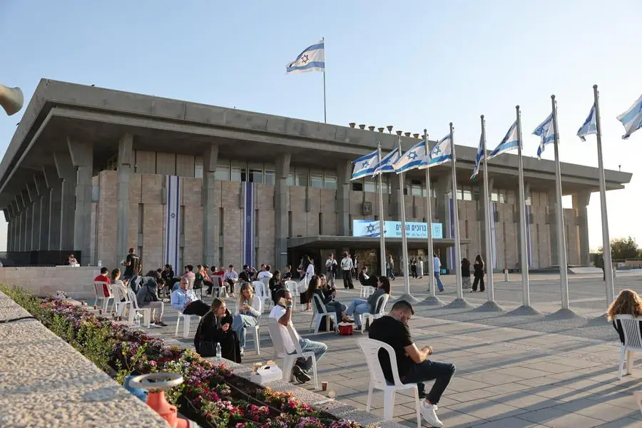 Persone sedute all’esterno della Knesset, il Parlamento israeliano, a Gerusalemme, il 28 ottobre 2026. La Commissione elettorale centrale è impegnata nella fase finale dello scrutinio delle elezioni legislative. Il Paese resta in una situazione di stallo politico, con i risultati che delineano un sostanziale testa a testa tra il blocco guidato dal premier Benjamin Netanyahu e quello dell’opposizione