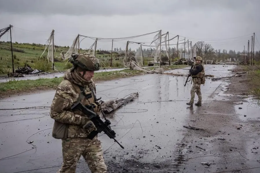 Militari delle Forze armate ucraine camminano lungo una strada accanto a una rete anti-drone, impegnati in una missione di protezione delle vie urbane dai droni russi nella città di Druzhkivka, nella regione di Donetsk