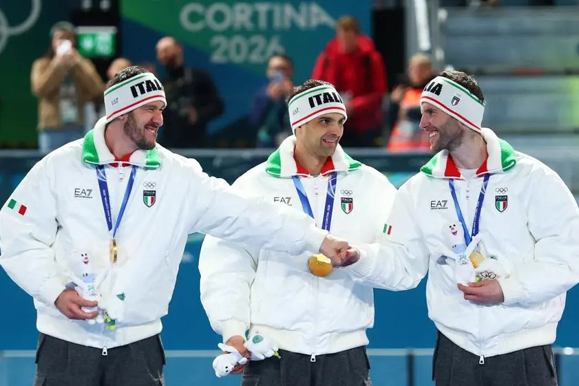 Milano Cortina 2026 Olympics - Speed Skating - Men's Team Pursuit Victory Ceremony - Milano Speed Skating Stadium, Milan, Italy - February 17, 2026. Gold medalists Davide Ghiotto of Italy, Michele Malfatti of Italy and Andrea Giovannini of Italy celebrate on the podium after winning the Men's Team Pursuit REUTERS/Yves Herman