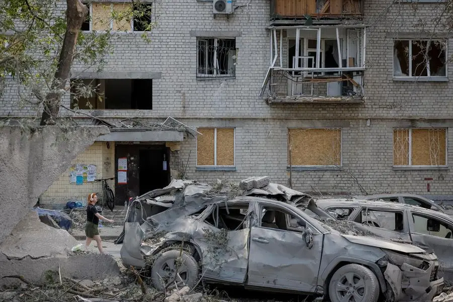 Un edificio danneggiato e auto distrutte da un attacco russo su Kyiv.
