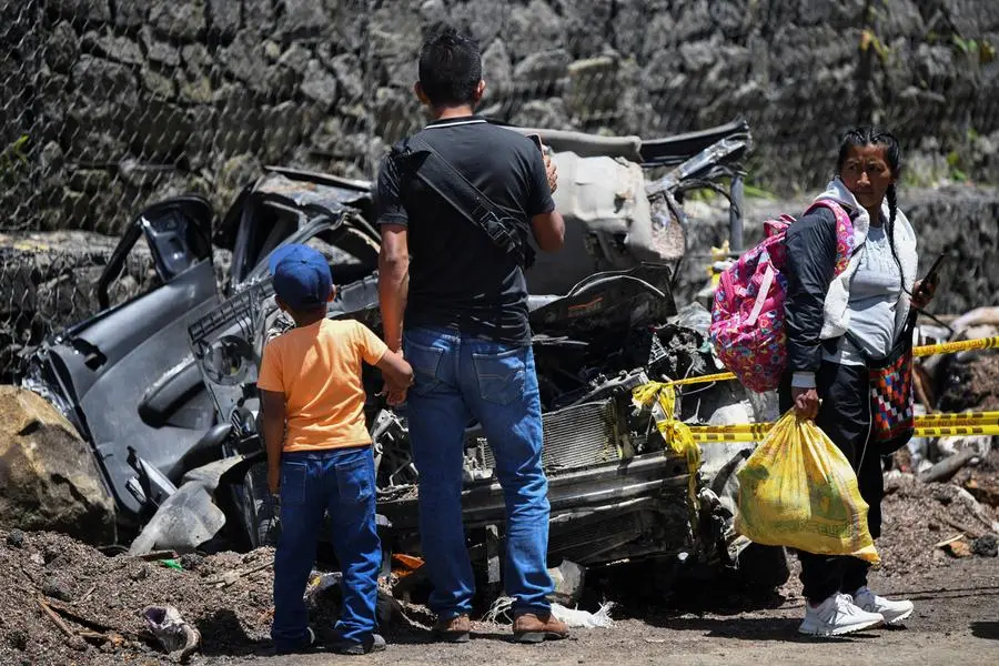 Alcune persone davanti a un veicolo distrutto da un attacco con esplosivo che ha ucciso pi\\u00F9 di una dozzina di civili sulla Via Panamericana in Colombia. , REUTERS