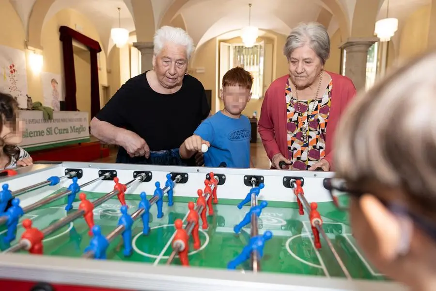 Alla Fondazione Ospedale Richiedei di Gussago nel bresciano, anziani a bambini si divertono insieme durante una partita di calcio balilla. , Federico Guida / Contrasto