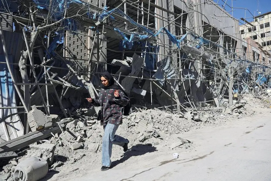 Una ragazza sola a piedi, nella Teheran devastata dopo i bombardamenti , Reuters