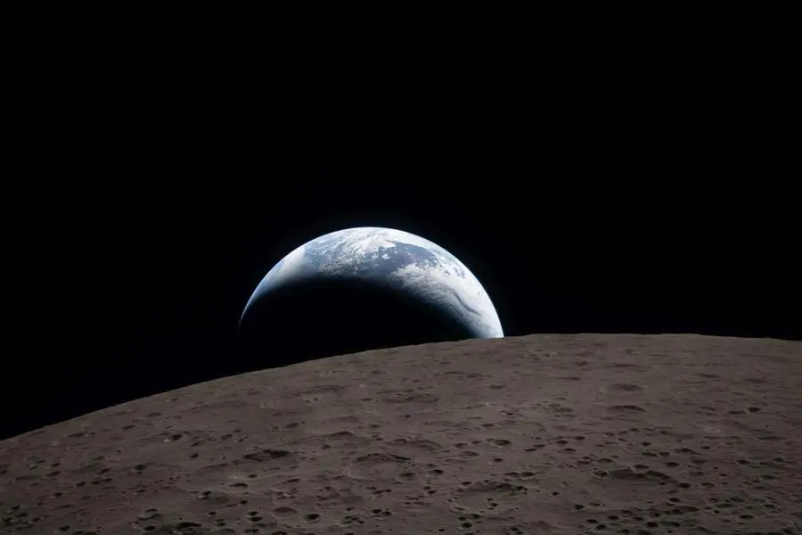 La Terra tramonta all’orizzonte lunare in questa immagine ripresa dalla capsula Orion durante il sorvolo della Luna dell’equipaggio di Artemis II, il 6 aprile 2026. In primo piano il cratere Ohm, con i suoi caratteristici bordi terrazzati e i rilievi centrali