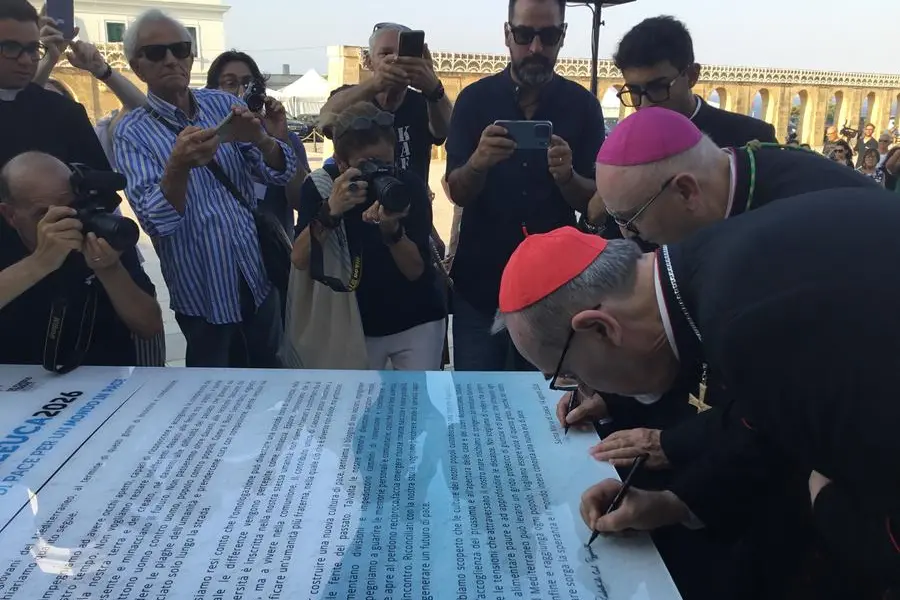 Il cardinale Pizzaballa mentre firma, insieme al vescovo Vito Angiuli, la Carta di Leuca 2026