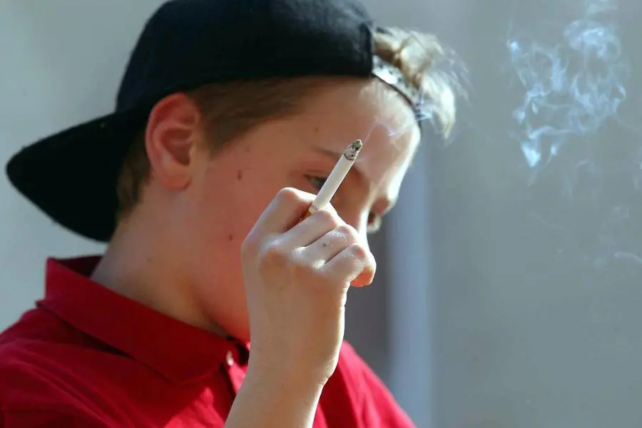 Un ragazzo fuma una sigaretta. 40 milioni di ragazzini tra 13 e 15 anni in tutto il mondo dichiarano di utilizzare almeno un prodotto del tabacco. , ANSA