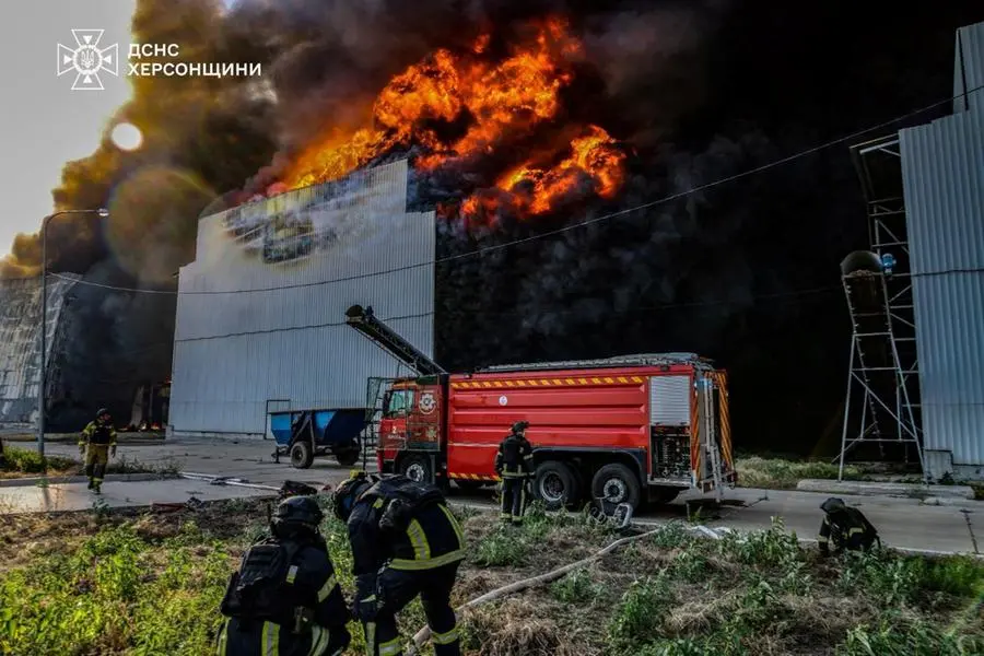 I vigili spengono le fiamme dopo un raid russo nella regione di Kherson.