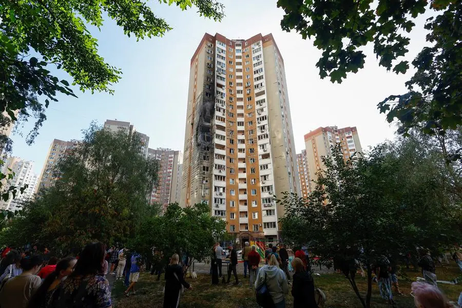Alcuni abitanti riuniti di fronte a un edificio residenziale colpito dai droni russi. , REUTERS