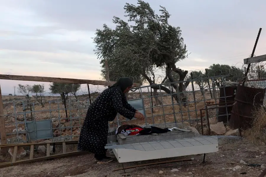 epa13275894 A member of the Bedouin Kaabneh family hangs out laundry at their residential compound in the West Bank village of Taybeh, east of Ramallah, 01 October 2026. The family has faced repeated harassment and property damage by Israeli settlers from nearby outposts in recent months. EPA/ATEF SAFADI