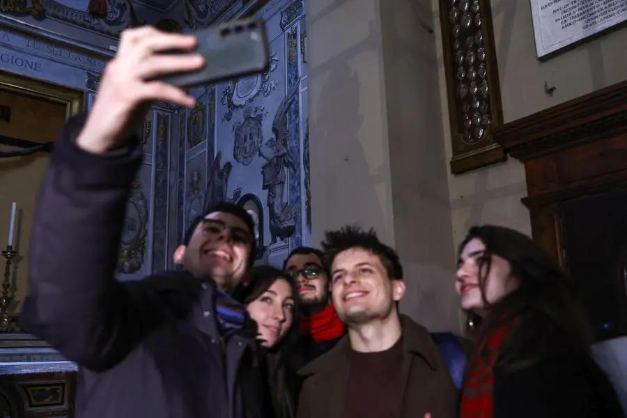 Un selfie di curiosi davanti dell’Angelo somigliante alla presidente del Consiglio Giorgia Meloni rimosso dal dipinto restaurato, presso la Basilica di San Lorenzo in Lucina a Roma