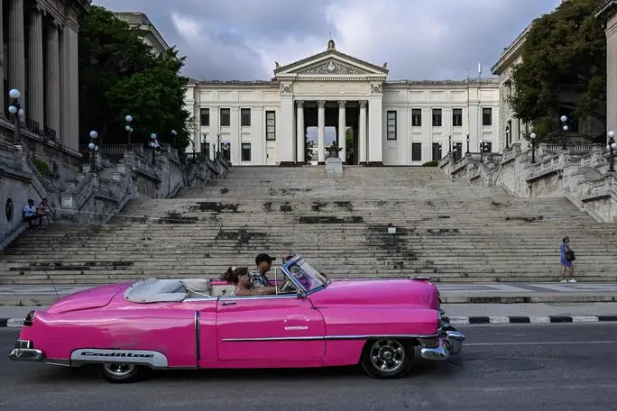 An old car drives past the University of Havana on May 13, 2026. Since February 2026, the fuel crisis in Cuba—marked by the oil blockade imposed by the United States—has left universities without in-person classes. Today, practical degrees such as architecture and design are surviving amid blackouts, shortages and slashed programmes. Training has become so fragmented that an entire generation fears they are being left professionally half-formed. (Photo by YAMIL LAGE / AFP)