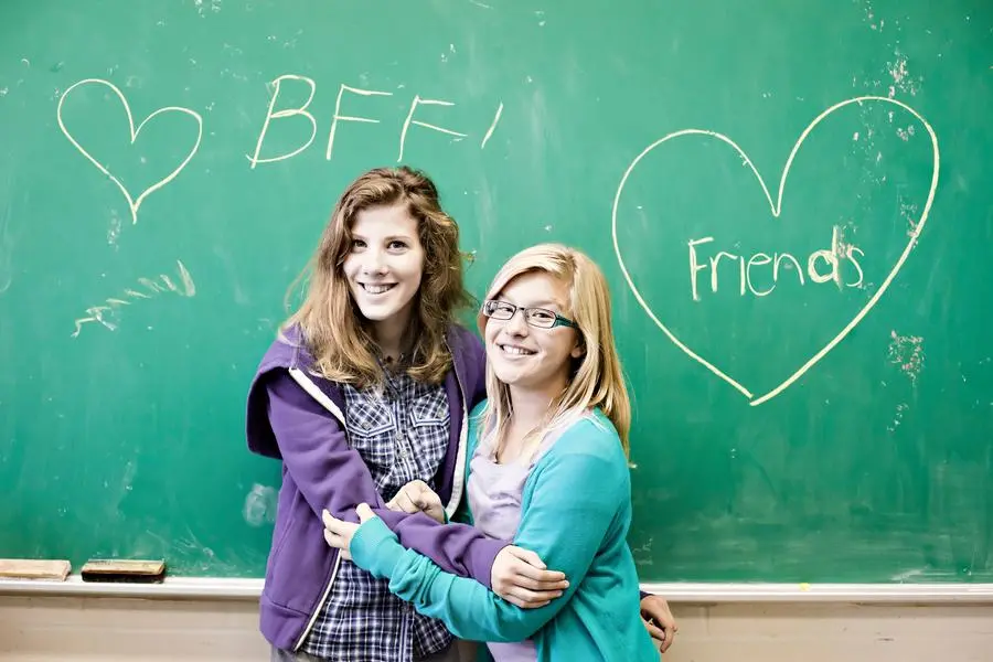 L\\'amicizia fra due compagne di scuola, un\\'immagine simbolica di relazioni, cura e affetto reciproco , iStockphoto