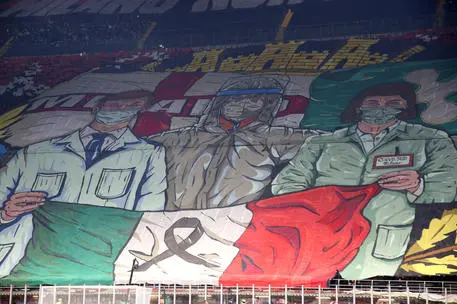 Milan supporters display a banner in memory of the victim of Covid-19 during the Italian serie A soccer match between AC Milan and Fc Inter at Giuseppe Meazza stadium in Milan, 7 November 2021. ANSA / MATTEO BAZZI