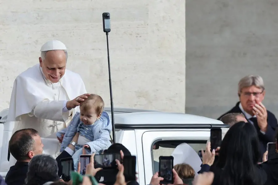 Papa Leone benedice un bambino durante l\\'udienza generale , REUTERS