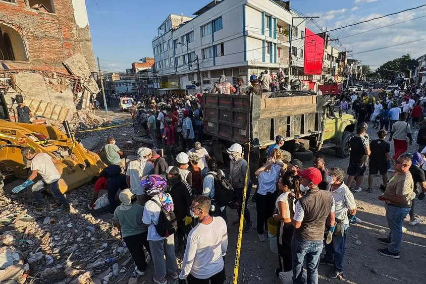 Residenti e soccorritori tra le macerie di alcuni edifici a Cali. , REUTERS