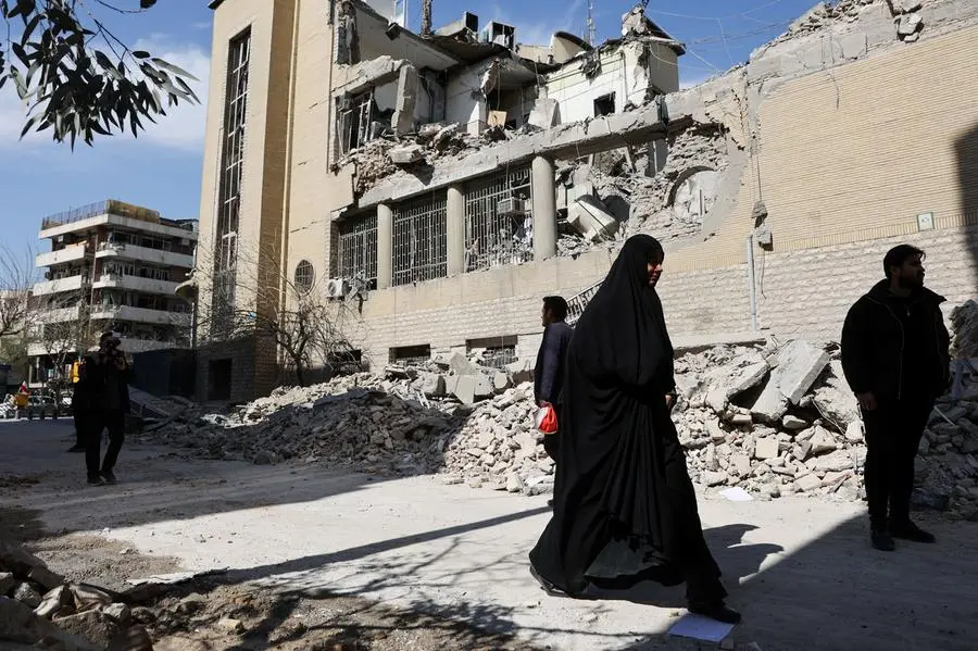 Alcune persone sulle macerie dopo un attacco a una stazione di polizia a Teheran , REUTERS