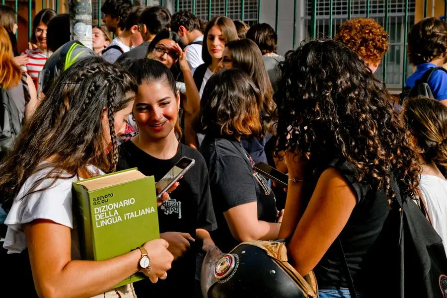 Studentesse e studenti con il vocabolario di italiano sotto braccio aspettano l\\'apertura della scuola al liceo Mercalli di Napoli, , ANSA