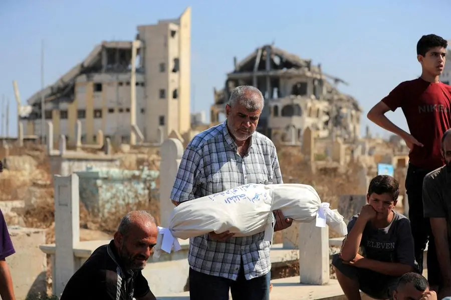 Un parente porta il corpo della piccola Ameera al-Masri, uccisa insieme ai genitori e ai tre fratelli in un raid israeliano contro la loro abitazione a Gaza City il 21 luglio scorso