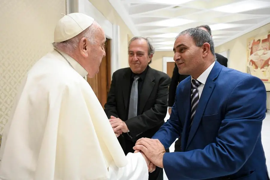 A handout picture provided by the Vatican Media shows Pope Francis (L) embraces the Arab Bassam Aramin (R) and the Israeli Rami Elhanan (C), fathers of the two girls killed during the Israeli Palestina war, in Vatican, 27 March 2024. ANSA/VATICAN MEDIA +++ ANSA PROVIDES ACCESS TO THIS HANDOUT PHOTO TO BE USED SOLELY TO ILLUSTRATE NEWS REPORTING OR COMMENTARY ON THE FACTS OR EVENTS DEPICTED IN THIS IMAGE; NO ARCHIVING; NO LICENSING +++ NPK +++